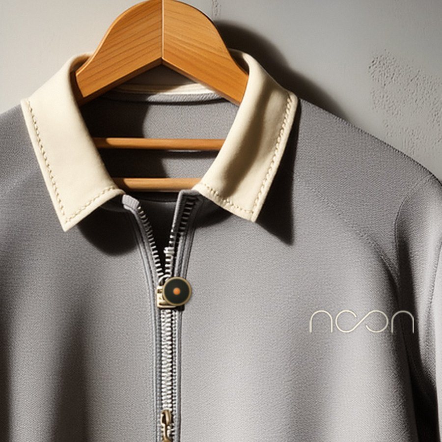 The limestone collar, the zip and the chest of the riding shirt close up, the word noon small in a tone of the cloth