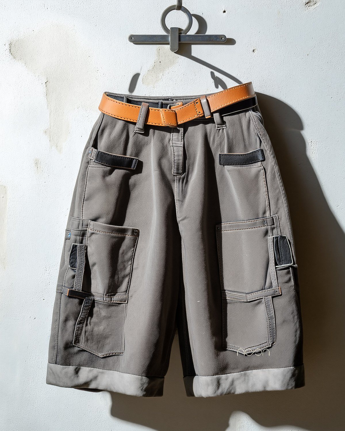 Grey knee-length work shorts with a tan leather belt
