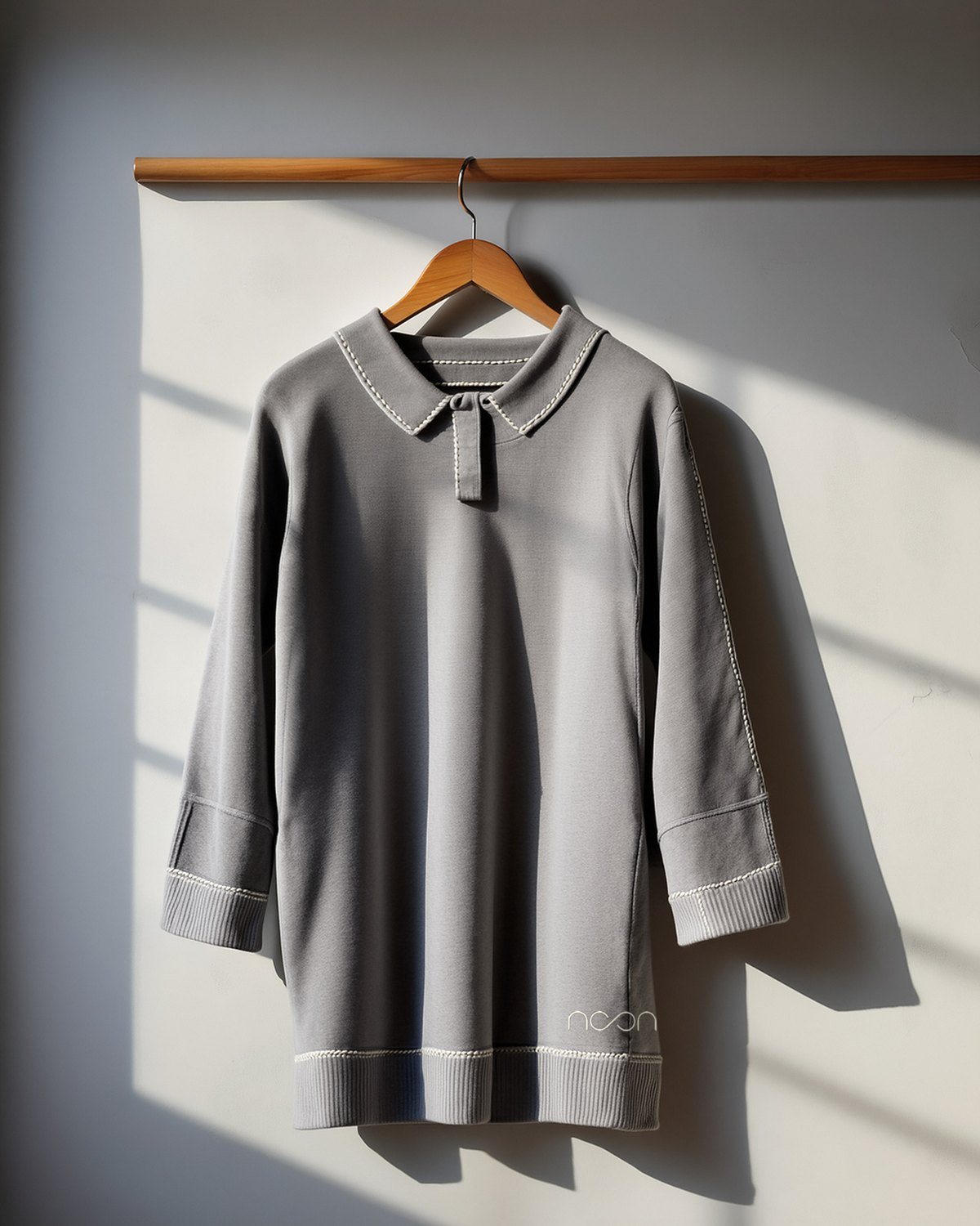 A grey tunic with a band collar, its placket and seams picked out in limestone saddle stitch