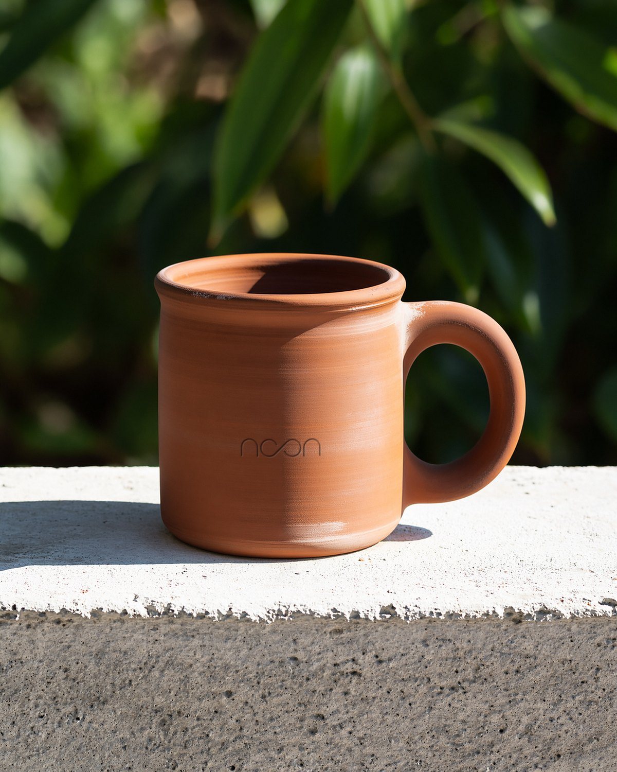 The same kind of mug seen whole, the word pressed low on its side