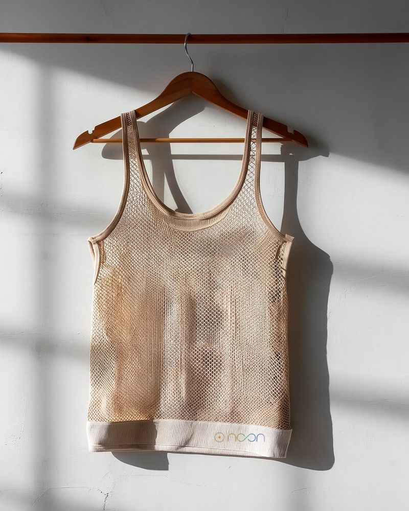 An open-mesh tank in sand, the wall showing through it
