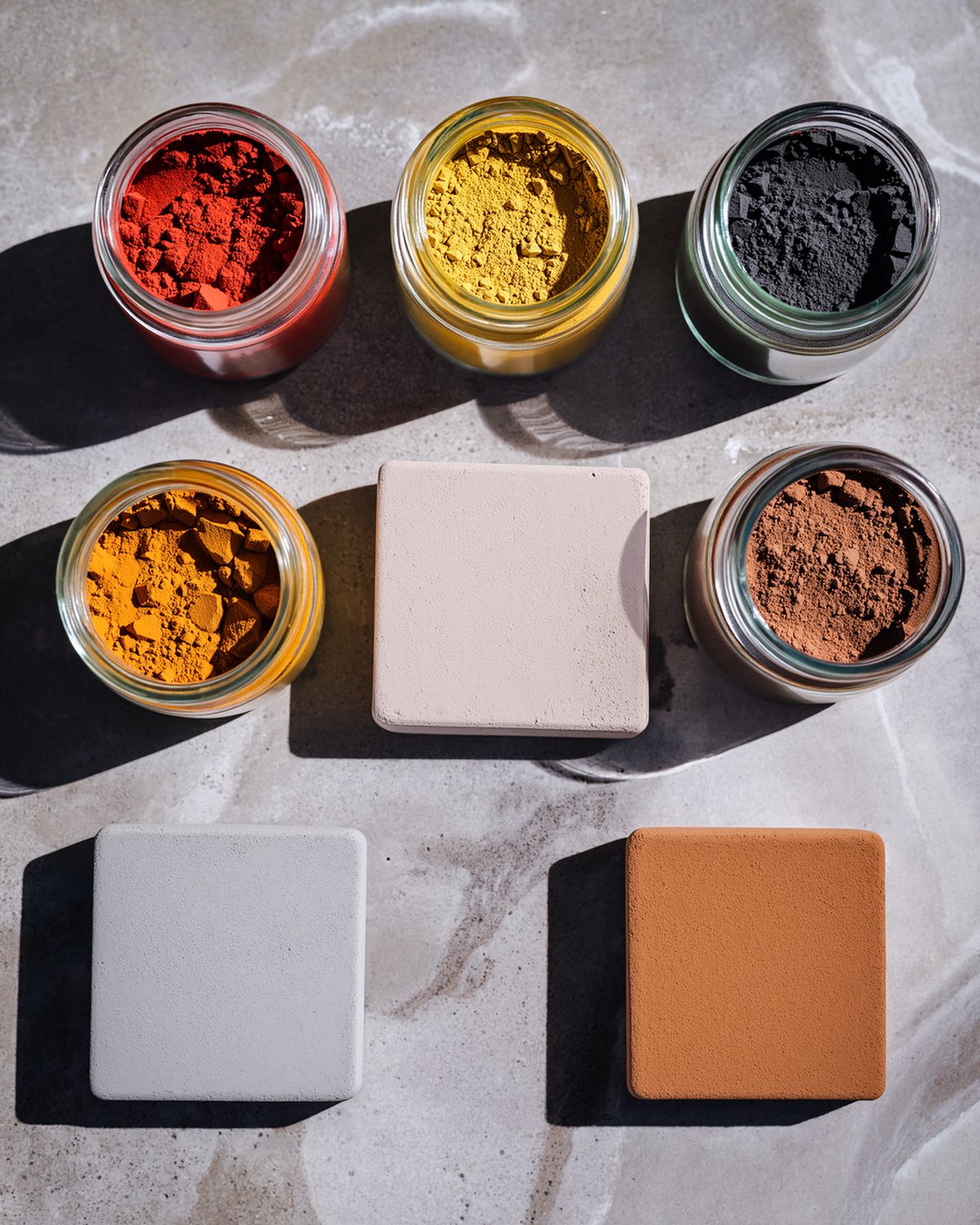 Jars of mineral pigment and small tiles of coloured concrete