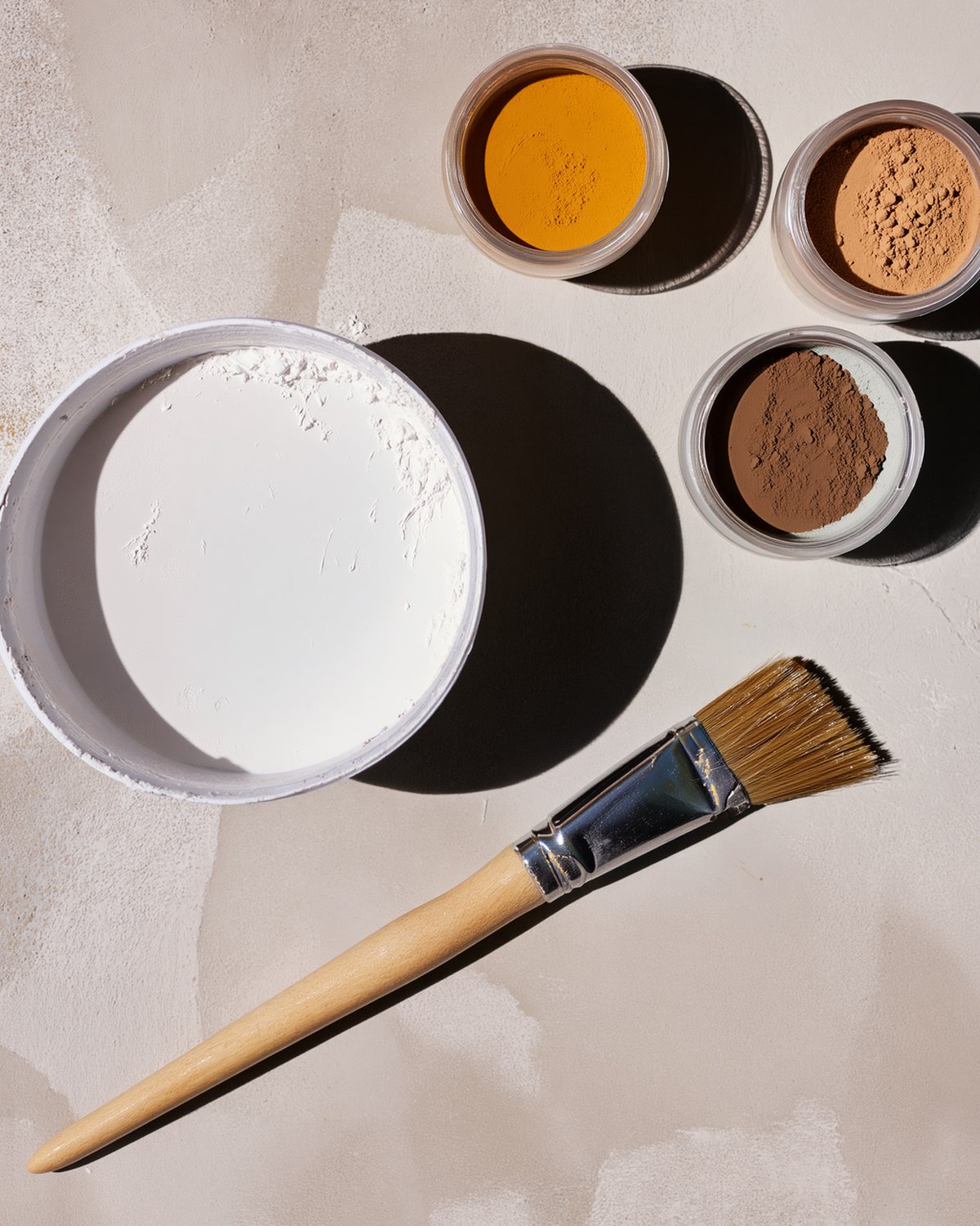 The mission wall kit laid out on a bench: limewash, lime putty, natural earth pigments