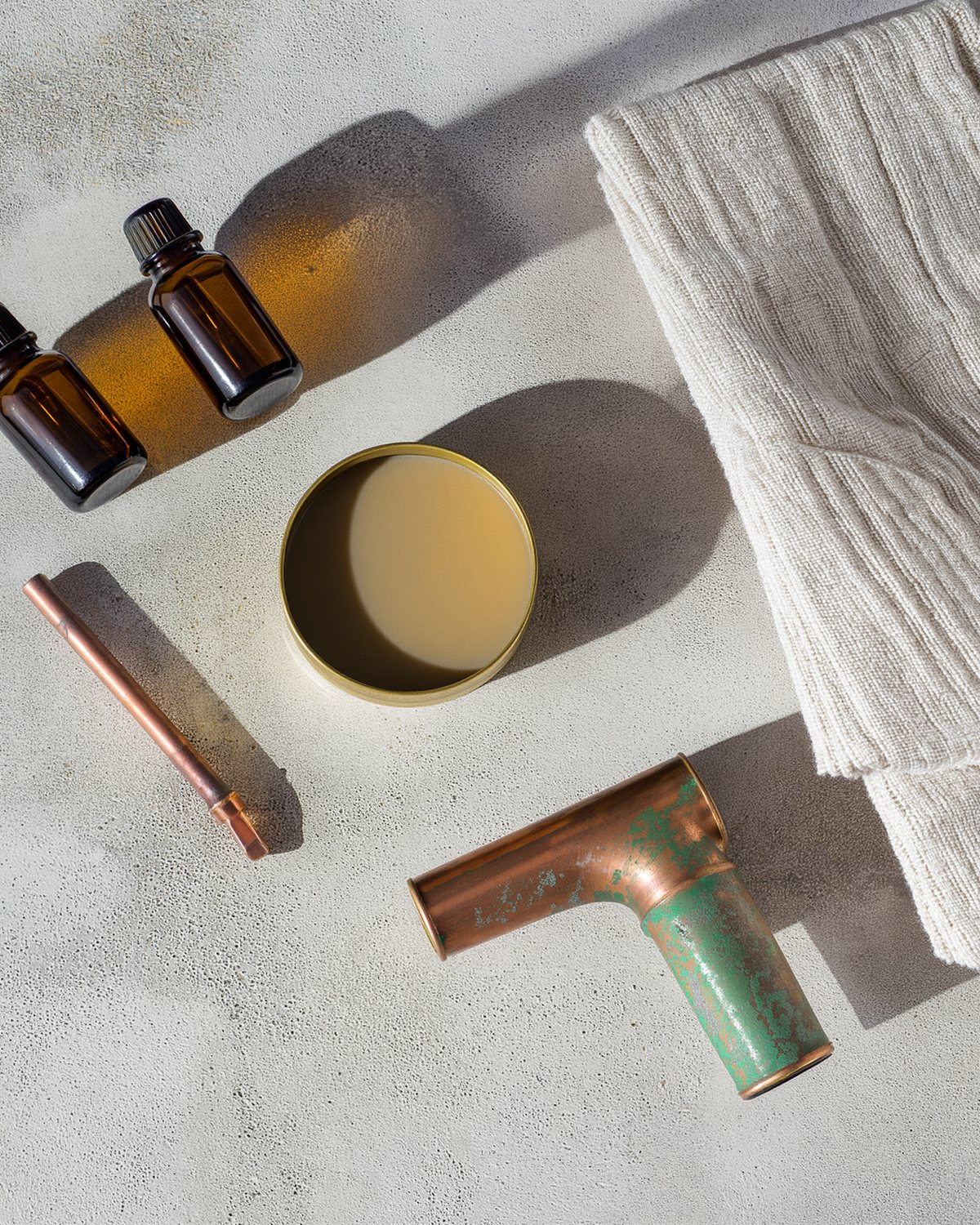 The green spout kit laid out on a bench: copper spouts, patinas, wax