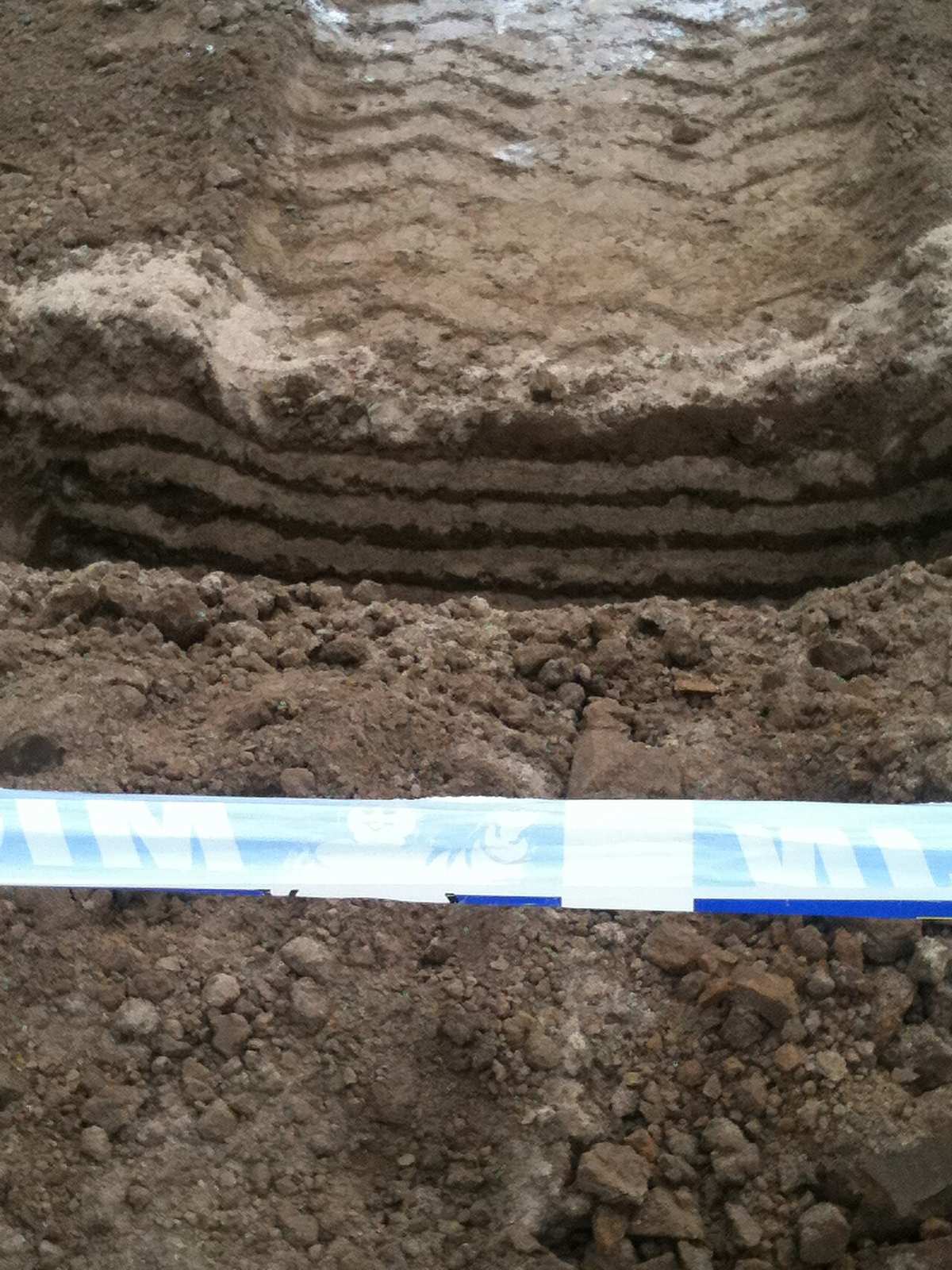 Tire tracks pressed into a soil excavation.