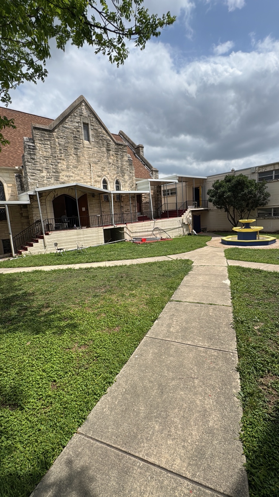 The repainted blue-and-yellow fountain in the mowed, tidied courtyard.