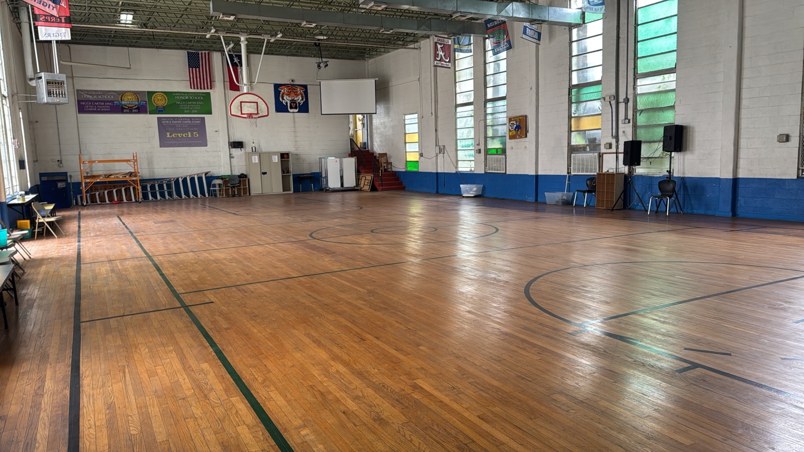 The cleaned-out school gymnasium with banners and basketball hoops.
