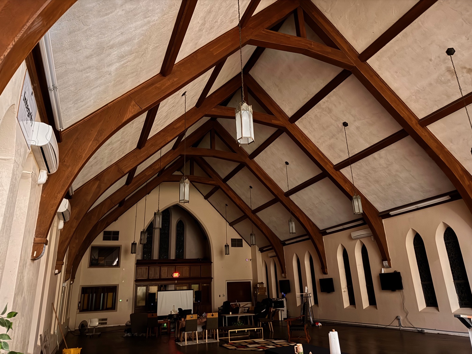 The grand timber-trussed assembly hall inside 702, with Gothic arched windows and a vaulted ceiling.