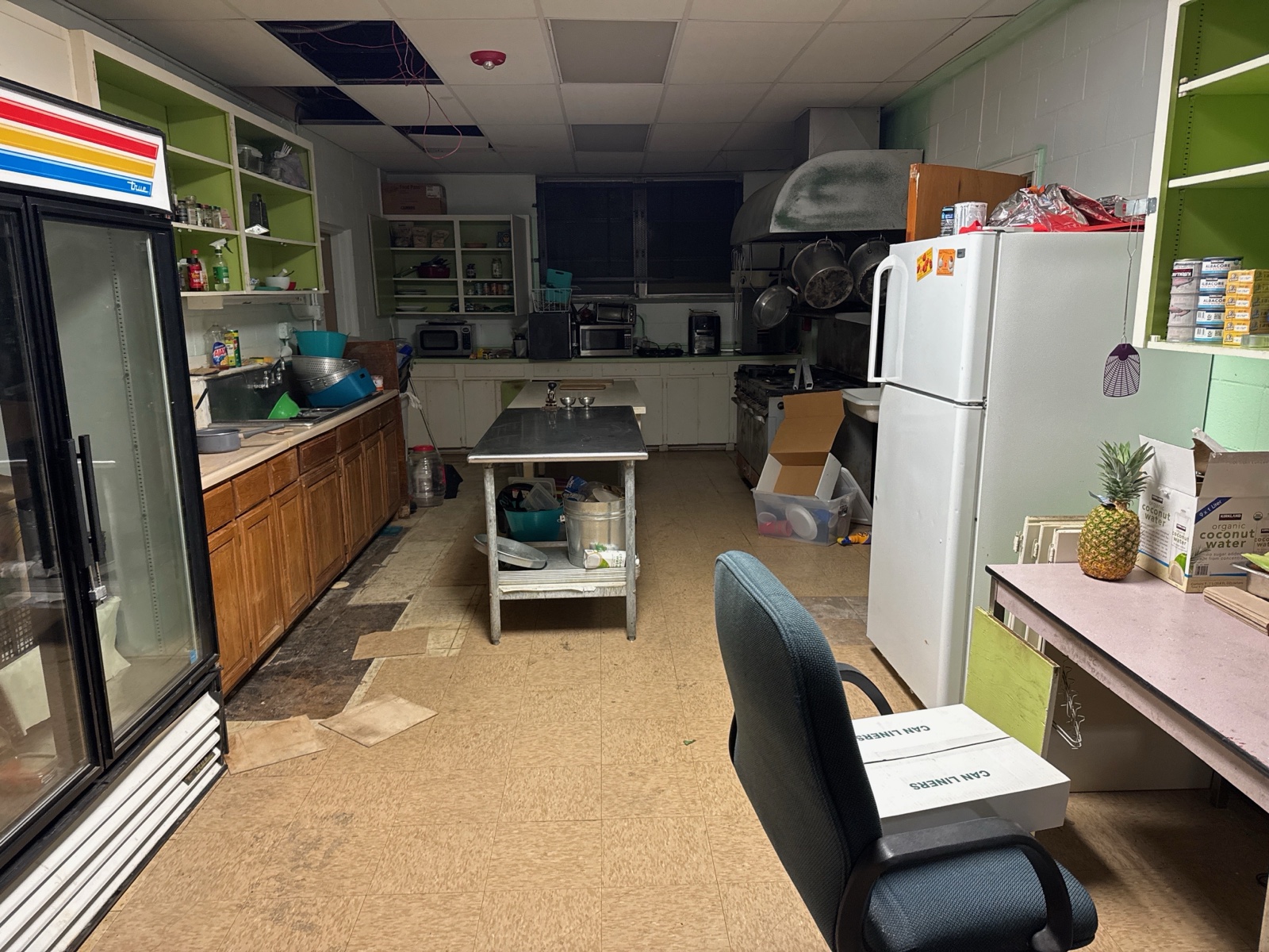 The cluttered, derelict institutional kitchen before clean-out.