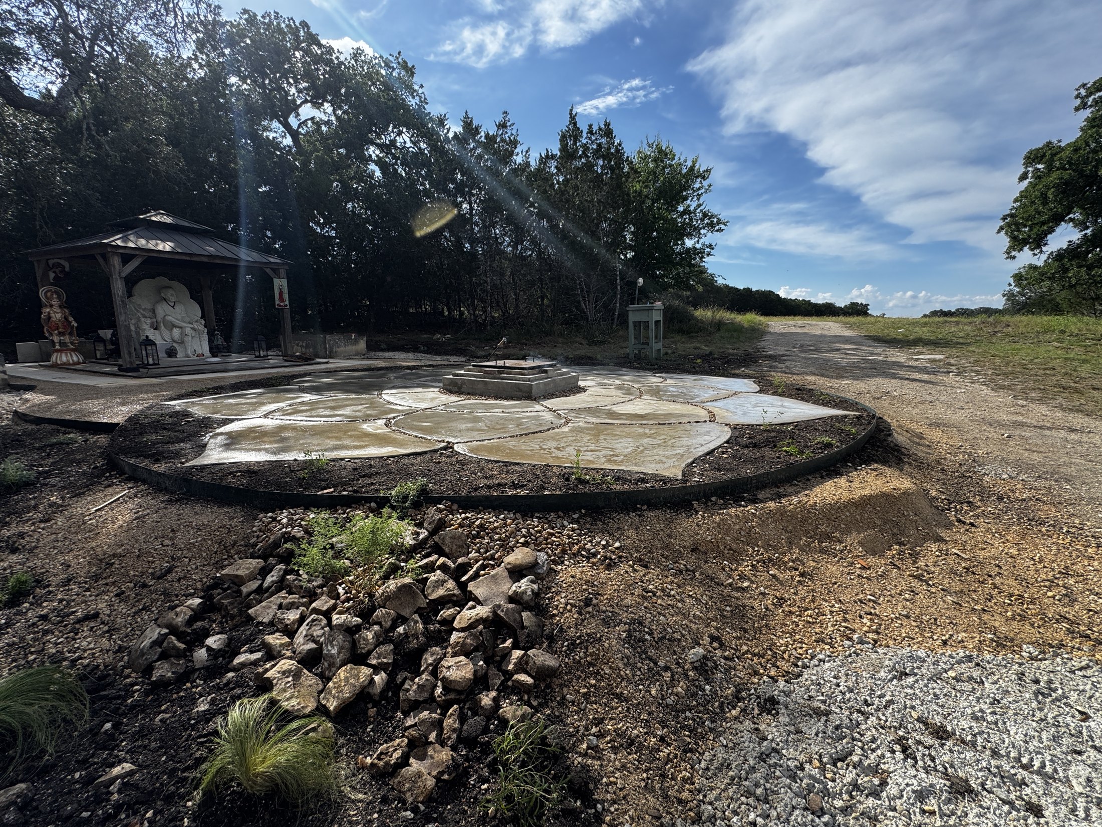 The finished Lotus under the live oaks, the shrine deck beyond, cloud overhead.