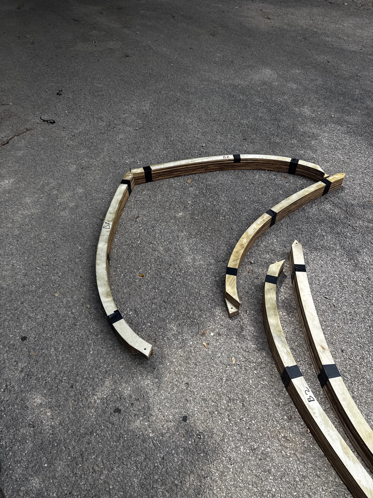 Curved laminated birch formwork pieces for the lotus petals, laid out and labeled.