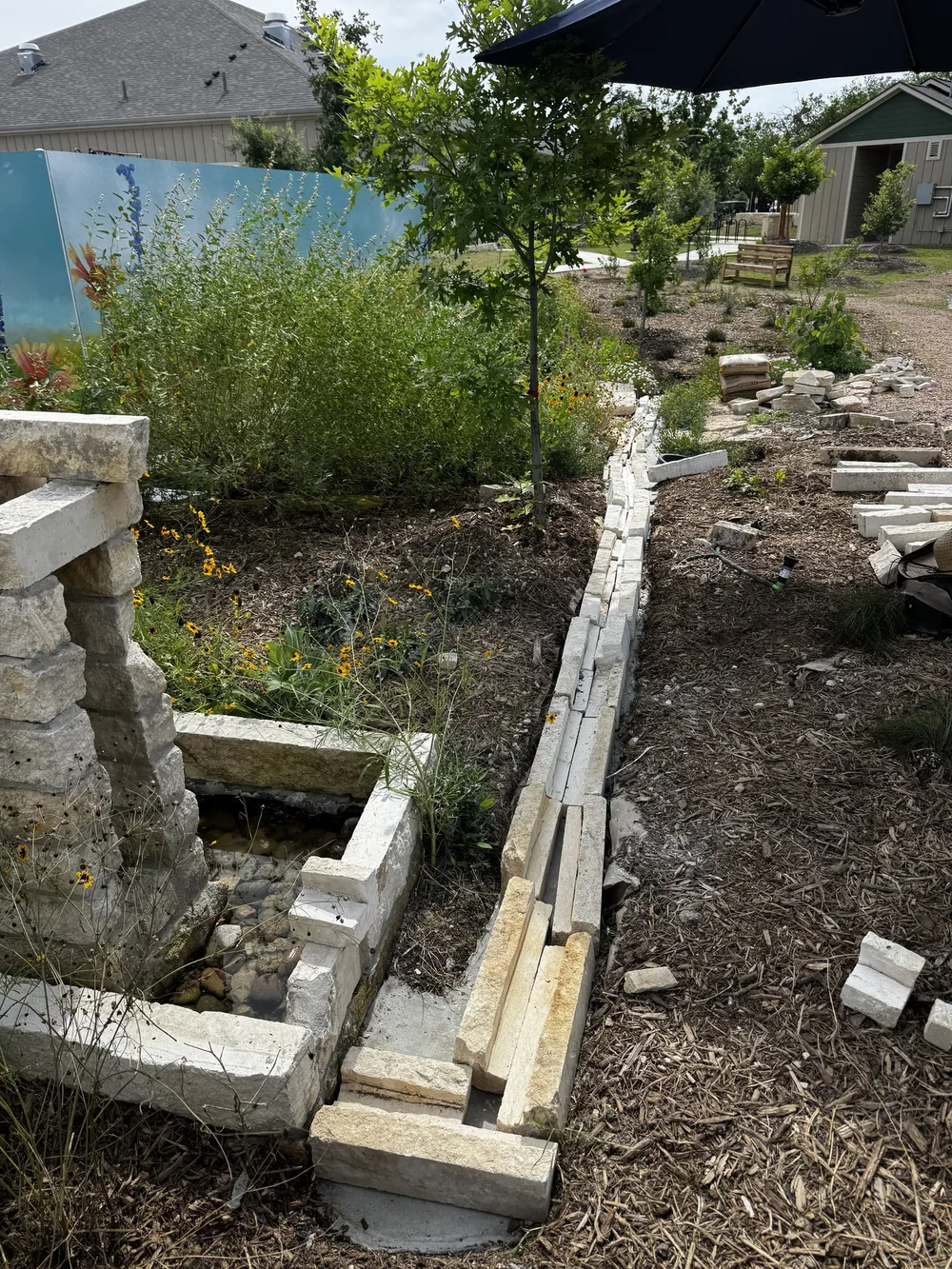A limestone rill under construction at Towne Twin, running from a cast basin down the slope.